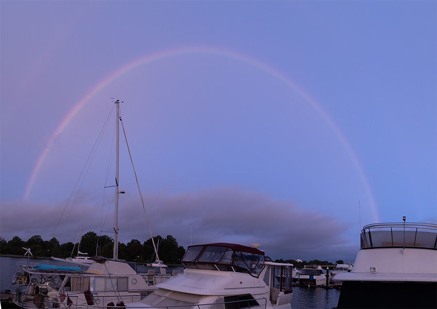 Full Arc Rainbow in Early Morning Light Over a Marina.